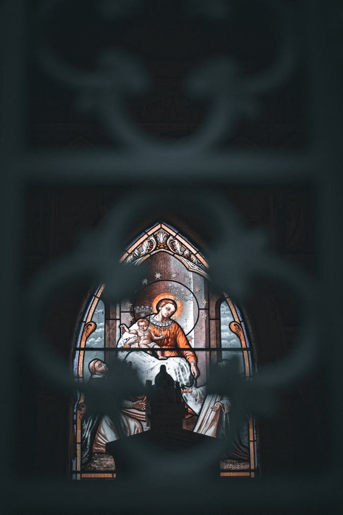 Close-up of a stained glass window depicting a religious scene in a cathedral.